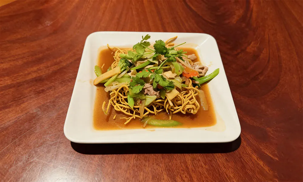 Crispy egg noodles with veggies and pork in savory sauce at Pho Thi, a Vietnamese Restaurant in Oregon City
