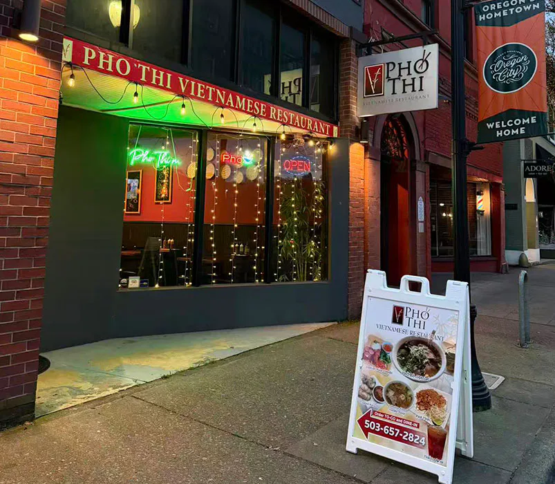Exterior of Pho Thi Vietnamese restaurant with sidewalk menu board at Pho Thi, a Vietnamese Restaurant in Oregon City